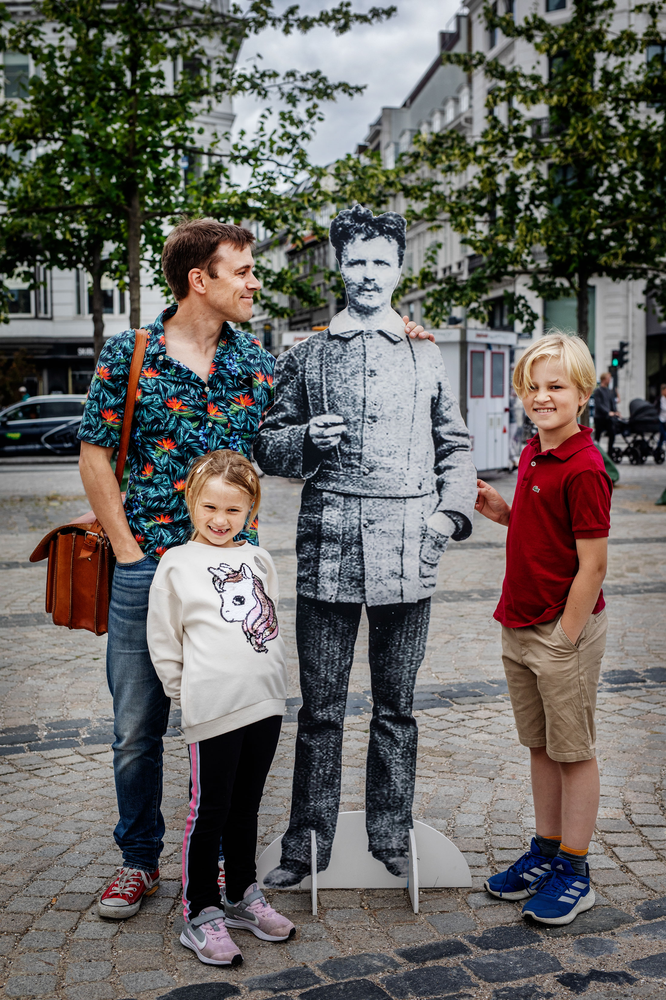 Karl-Oskar Stål med familj och pappersfigur av deras avlägsna släkting August Strindberg.